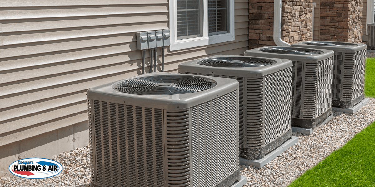 heat pump outdoor air conditioning units located on side of house